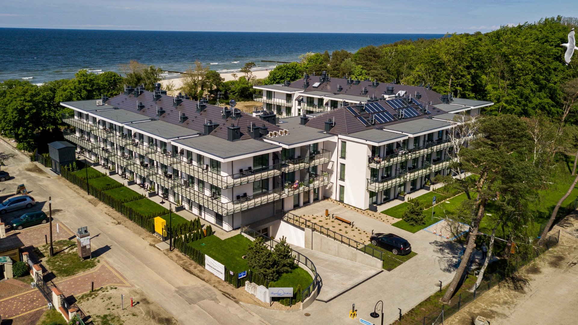 Nowoczesny apartamentowiec przy plaży z balkonami i widokiem na morze